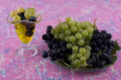 Preview: Red and green grapes in a glass of wine and in a platter