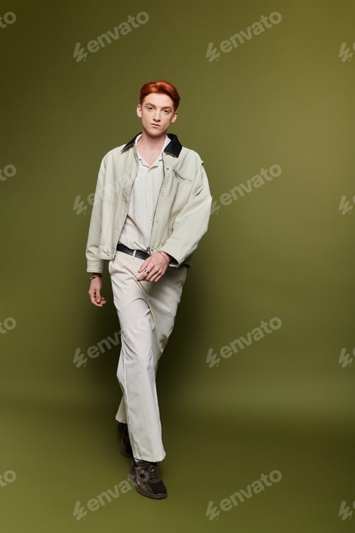 Preview: Handsome young man walking confidently with emotional expression against a green backdrop