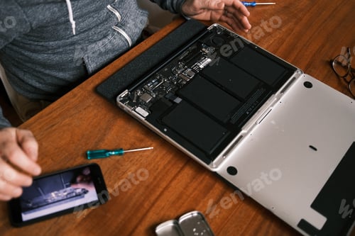 Preview: Repairing Laptop Computer with Screwdrivers on Wooden Desk