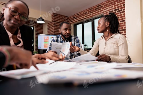 Preview: Team of colleagues analyzing documents in office