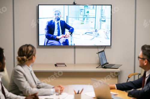 Preview: Intercultural audience looking at mature businessman on display