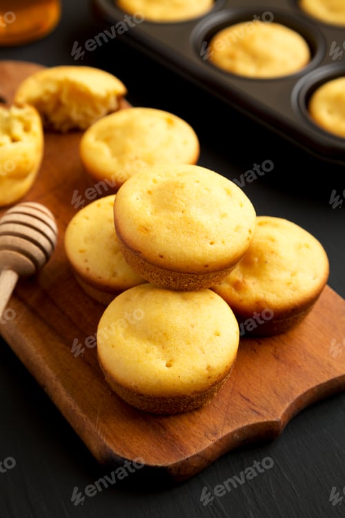 Preview: Homemade Cornbread Muffins on a rustic wooden board, low angle view. Close-up.