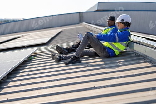 Preview: Engineer on rooftop sitting next to solar panels rest sitting relaxation after work completed