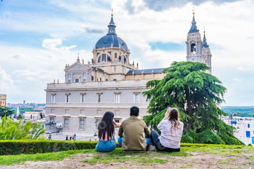 Preview: Tourist friends visiting Madrid city on summer vacation. Sitting looking at the Almudena