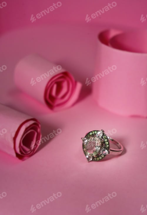 Preview: Vertical shot of a precious ring on a pink surface