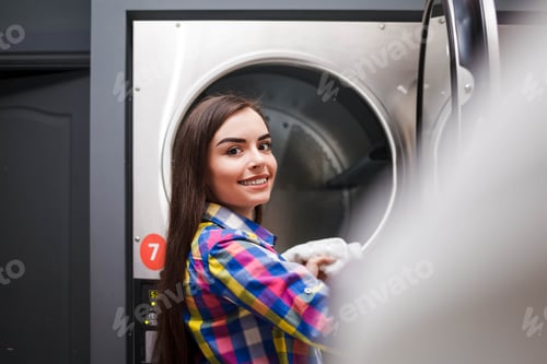 Preview: self serviece laundrette client takes things out of the dryer