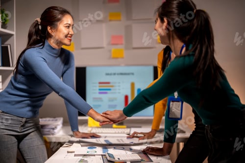Preview: Two women shaking hands in front of a computer monitor with a slide titled "Sale