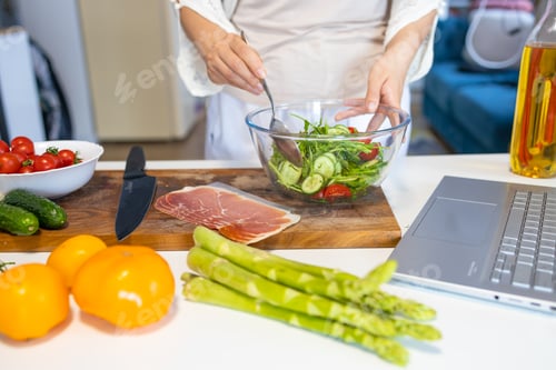 Preview: Young woman making a salad in the kitchen