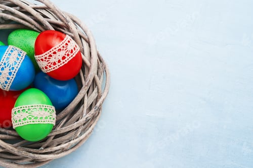 Preview: Easter eggs decorated with lace on blue background. Copy space. Easter celebration concept.
