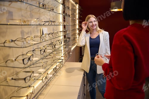Preview: Blonde woman tries on a stylish model of glasses
