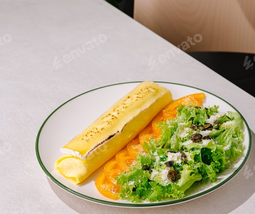 Preview: Delicious plate of crepes with fresh greens and sliced tomatoes served at brunch