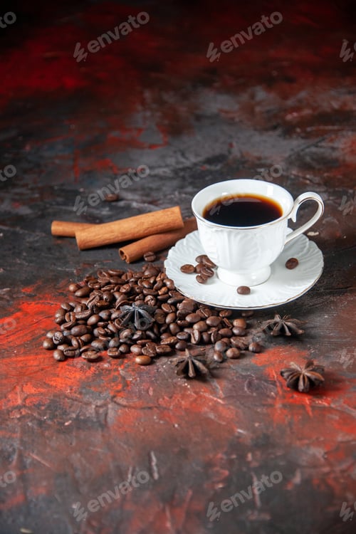 Preview: Vertical view of delicious coffee in a white cup and roasted beans around it cinnamon limes on mix