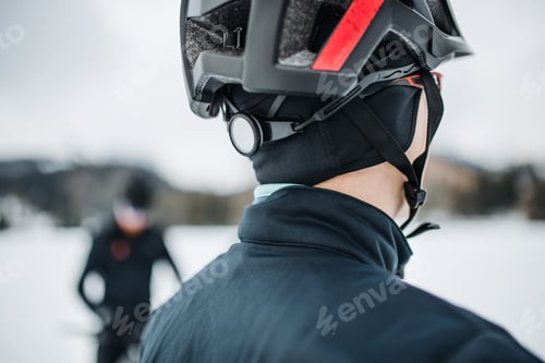 Preview: A rear view of mountain biker standing outdoors in winter, close-up