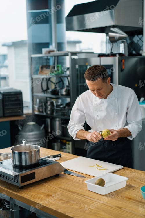 Preview: professional chef cutting fruit with knife to prepare oatmeal breakfast healthy food concept