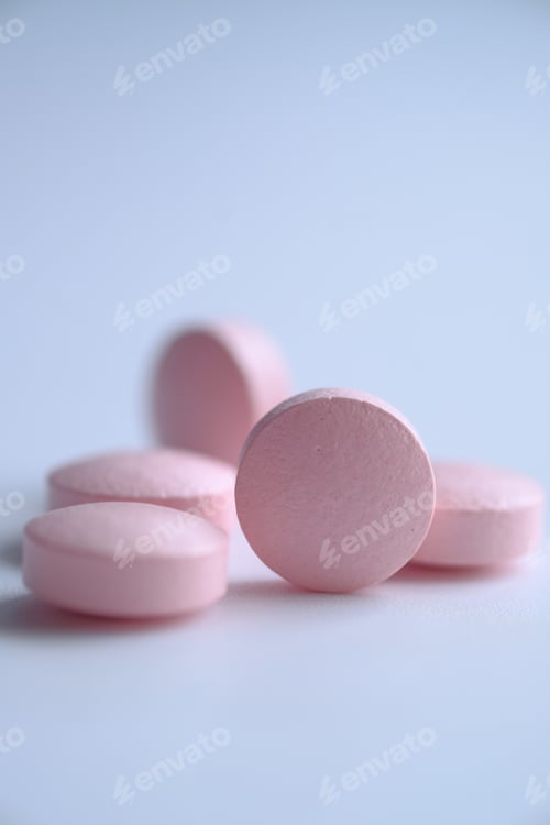 Preview: A closeup view of soft pink tablets displayed beautifully on a pristine white background