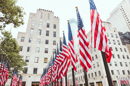 Preview: low angle view of american flags and buildings, new york, usa
