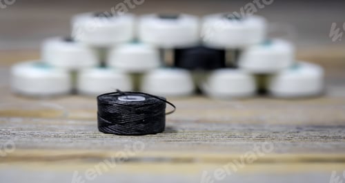 Preview: Small sewing threads on wooden background