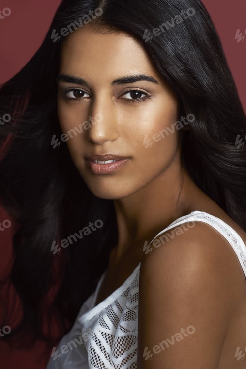Preview: Purely beautiful. Closeup portrait of a beautiful indian woman against a red background.