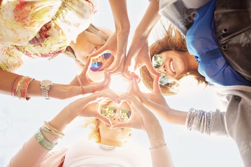 Preview: Smiling Women Making Heart Shapes with Hands Outdoors
