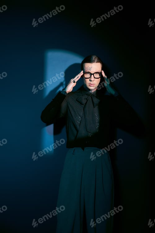 Preview: Handsome young man exudes confidence in stylish attire against a dark backdrop