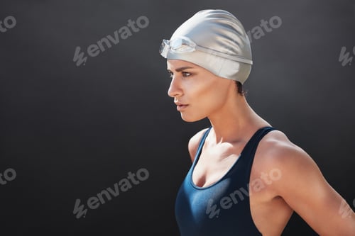 Preview: Fit young woman in swimming costume looking away