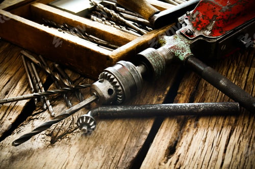Preview: Old drill, box with drills on wooden background.
