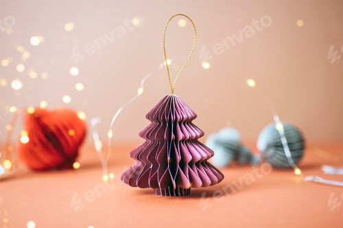 Preview: Paper Christmas decoration on beige background with golden lights, close-up