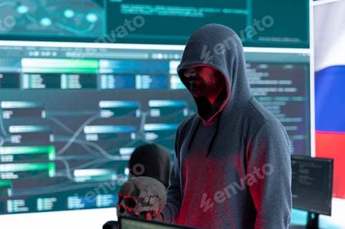 Preview: Digital outlaw hacker in a dark hood issuing cyber threats with a human skull