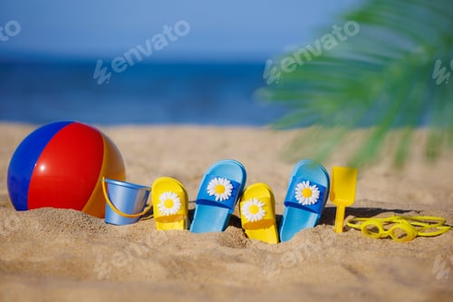 Preview: Kids flip-flops, beach ball and snorkel on the sand. Summer vacation concept