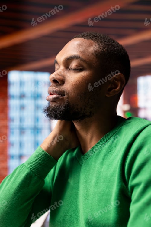 Preview: Overworked man at home closing eyes to relax after long hard day at work