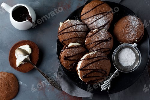 Preview: Chocolate cookies of Woopie Cookie with mascarpone cream on a gray dark concrete background. Selecti
