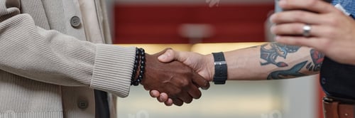 Preview: Header Image of Black Man Meeting Male Partner with Handshake in Business Center Hallway