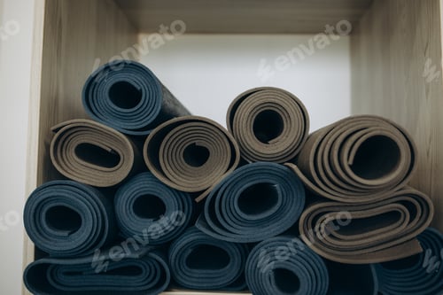 Preview: Many colored fitness and yoga mats, twisted into rolls, end view, on white background, isolate