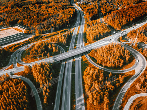 Preview: Aerial view of highway and overpass with autumn color woods on a fall day in Finland.