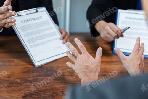 Preview: Businessmen discussing terms of contract and insurance during meeting