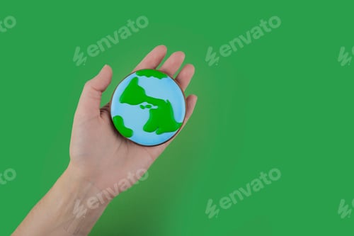 Preview: Earth Day concept. Сookie in shape of Earth in hand.