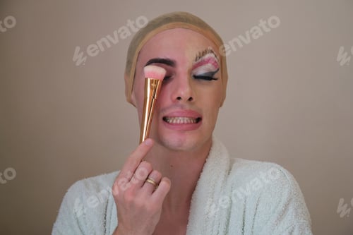 Preview: Half man half woman make up person. Drag queen person with a make-up brush.