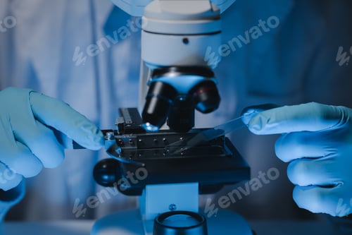 Preview: A scientist is studying samples using a microscope to study and develop the field of microbiology, M