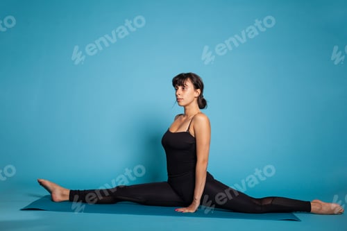 Preview: Personal trainer sitting in splits streching legs muscles