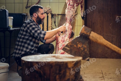 Preview: Close up image of axe over bearded butcher on background.