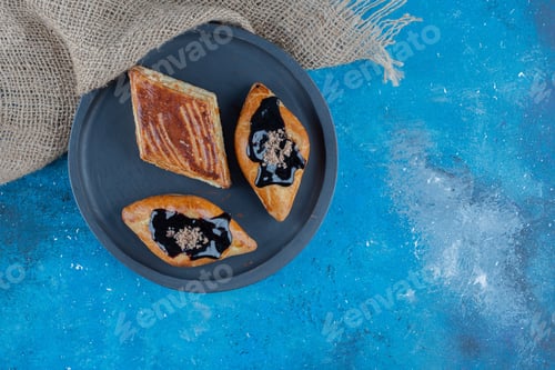 Preview: three cookies on the board next to towel ,on the blue background