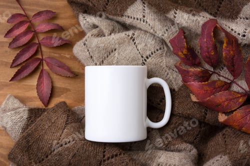 Preview: White coffee mug mockup with knitted blanket and red fall leaves