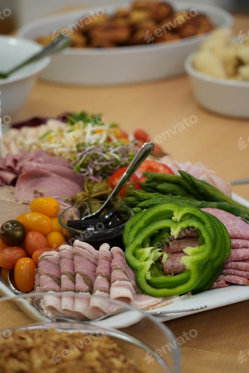 Preview: Vertical shot of a wooden table with a platter full of various cooked meats and vegetables