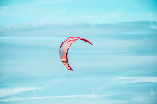 Preview: Kitesurfing or paragliding parachute high in blue sky with control lines