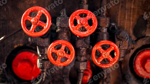 Preview: Closeup photo of red painted vavles and black pipes of vintage high pressure system on factory
