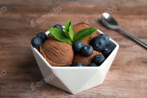 Preview: Bowl of chocolate ice cream and blueberries on wooden table
