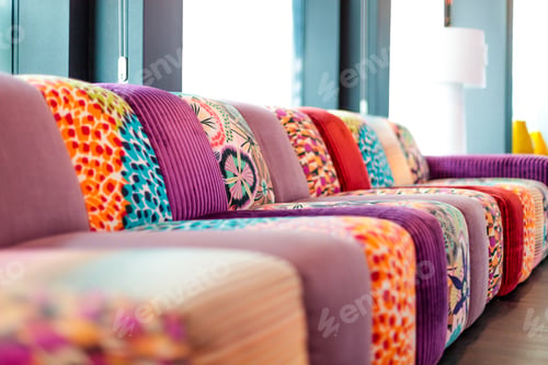 Preview: Puffy couch with interesting colorful textures inside a room with a blurred background