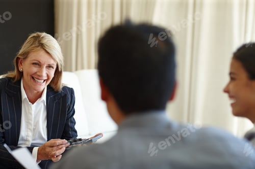 Preview: Shes making sure it all adds up. Shot of a smiling woman using a calculator in a seated meeting.