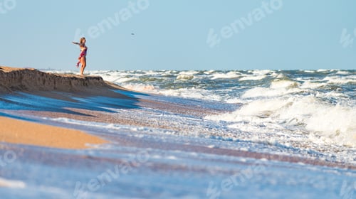 Preview: Joyful young woman enjoys stormy waves