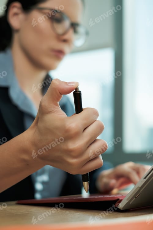 Preview: Bored Businesswoman Clicking Pen Repeatedly While Working at Office